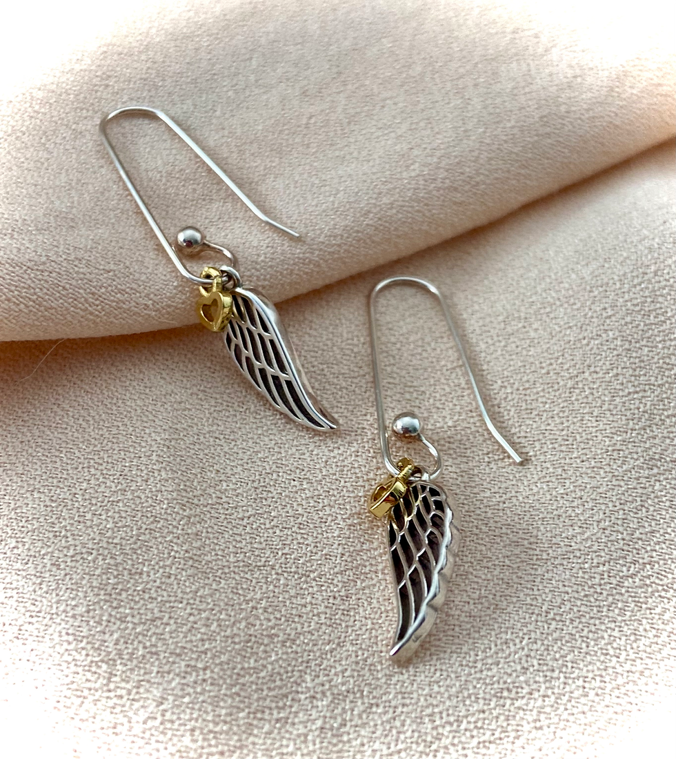 Thumbnail: sterling silver angel wing drop earrings laid down