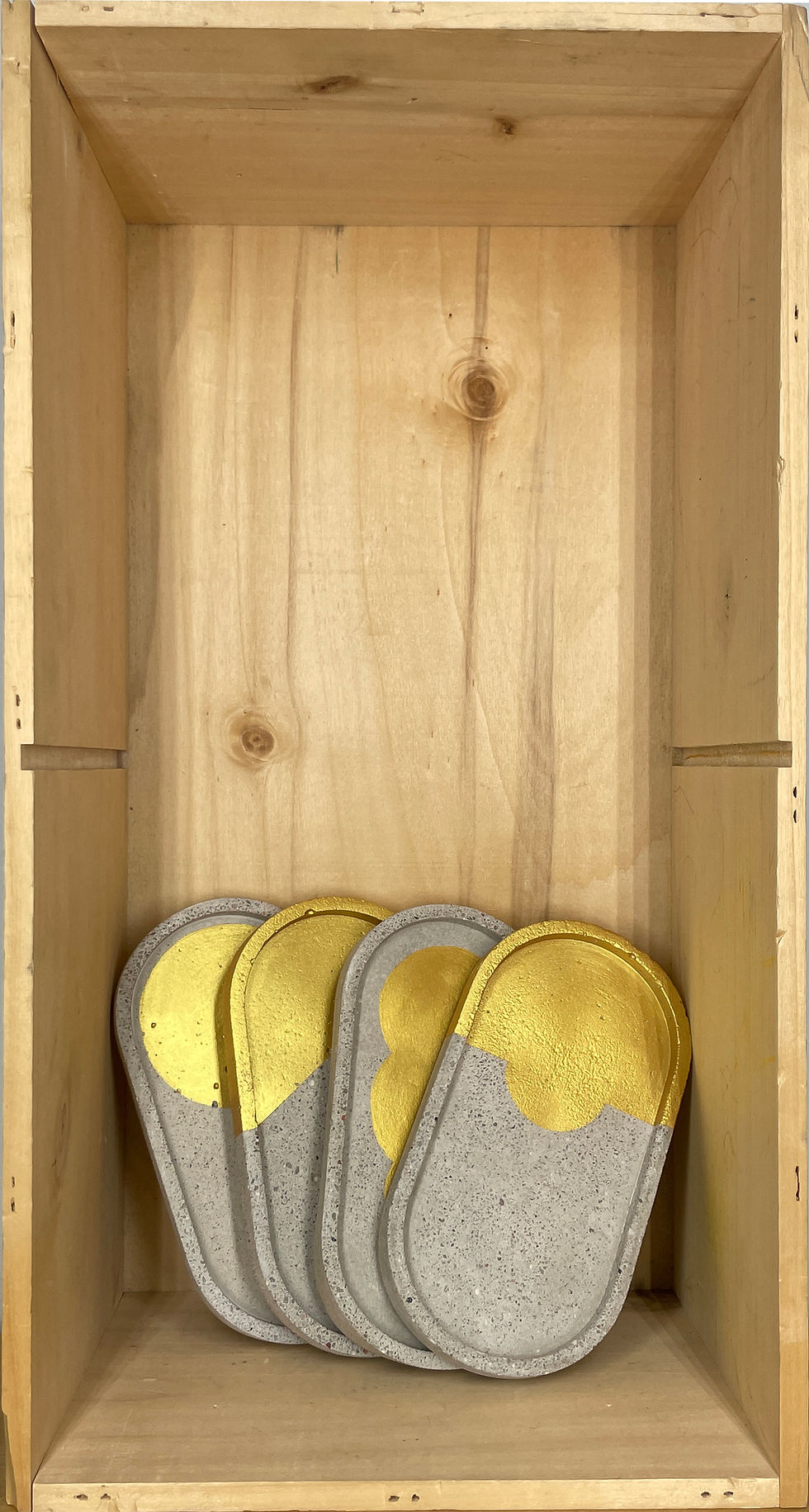 Miniaturbild: Vier goldene Schuhuntersetzer liegen in einem Holzschrank. Beton Untersetzer Gr. S&M