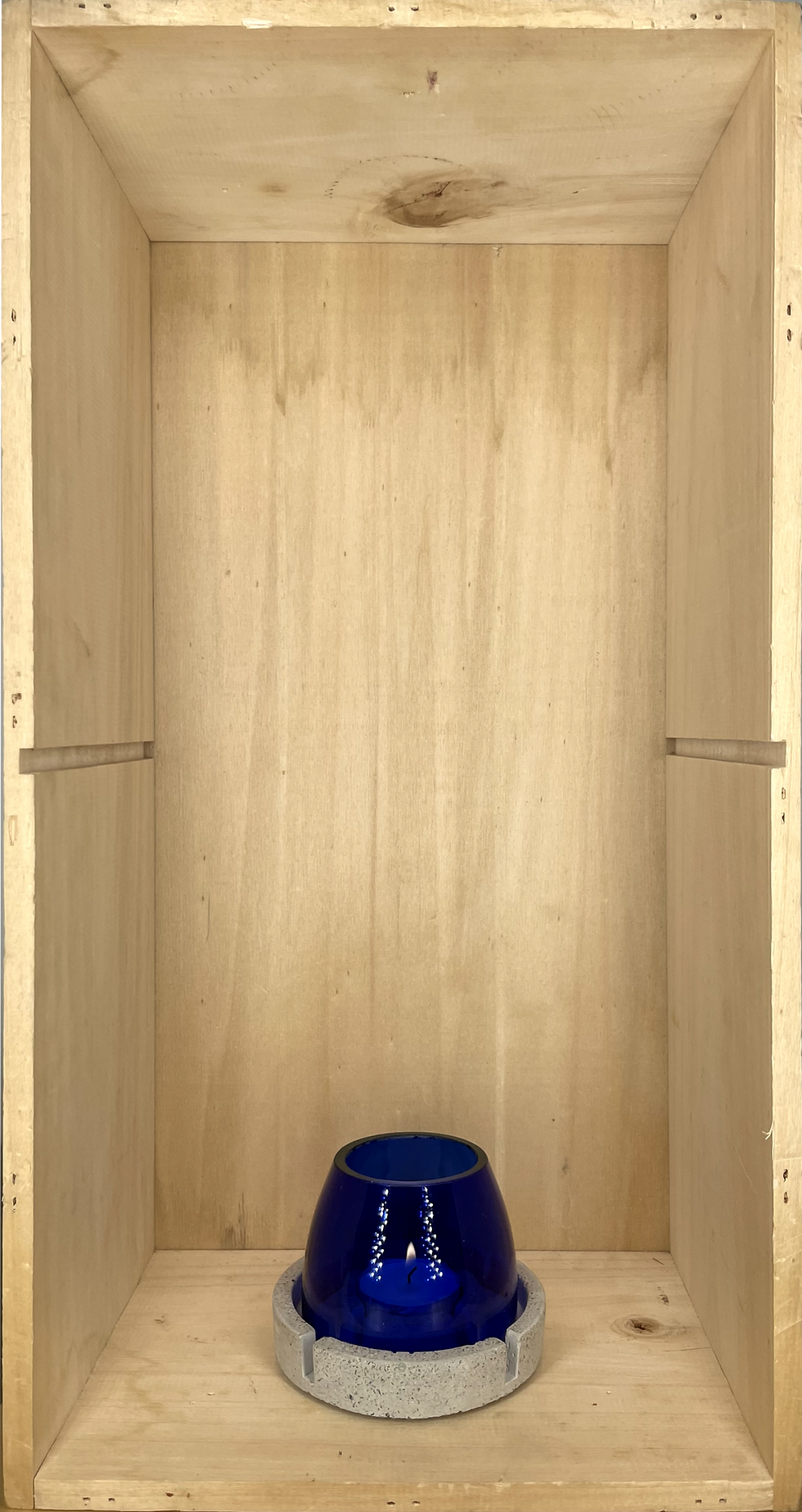 Miniaturbild: Innenansicht einer Holzbox mit blauem Becher am Boden, helles Holz