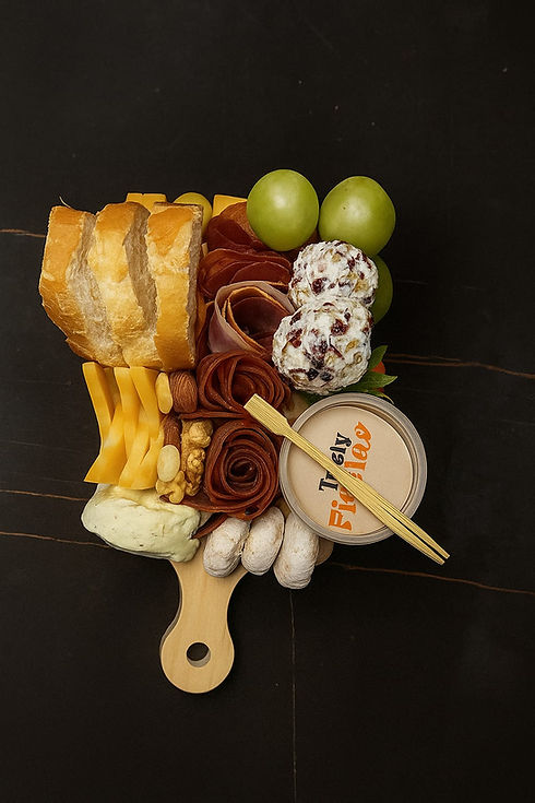 Carnes frías: Jamón Serrano, Chorizo Salamanca, Salchichón y Lomo Embuchado. Quesos: cremoso queso crema, intenso cheddar, bolitas de queso artesanales y queso mármol. Acompañamientos dulces y salados: aceitunas, nueces, uvas frescas, fresas jugosas. Pan y galletas: rebanadas de baguette recién horneada, galletas de habanero y galletas de nuez. Detalles gourmet: chocolate Turín, ate de zarzamora, miel natural y mermelada de chipotle artesanal.