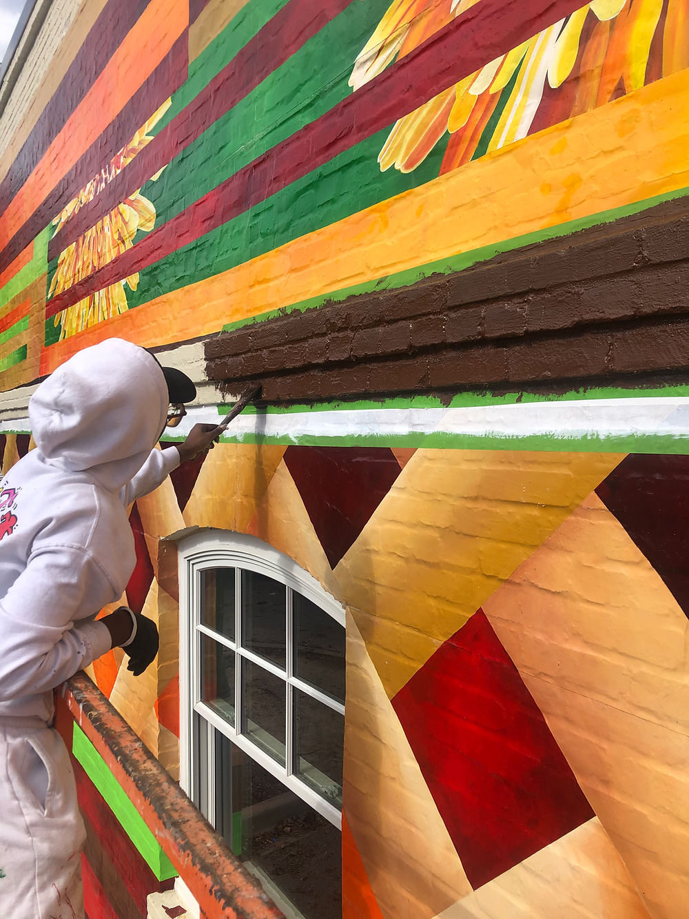 Contractor painting vibrant building mural