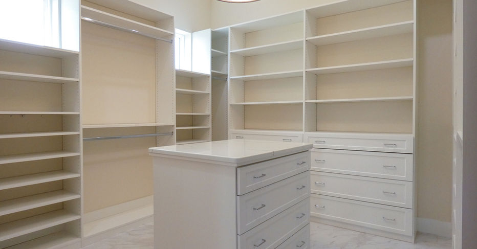 White luxury walk-in closet with shelves and drawers, and ceiling lamp.