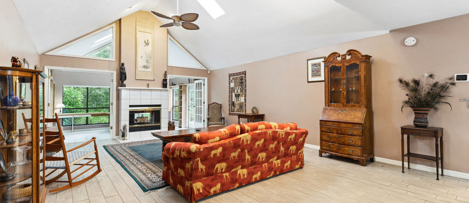 Spacious living room with large windows, fireplace, and comfortable seating arrangement.