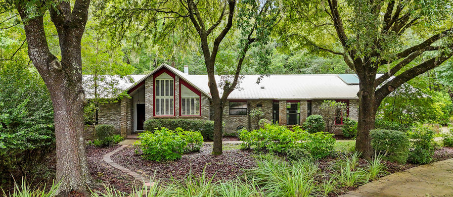 Exterior view of a house surrounded by trees and green plants Blues Creek.