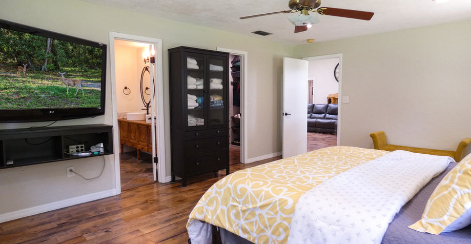 Bedroom with TV, King bed, Closet, and Bathroom open door overview