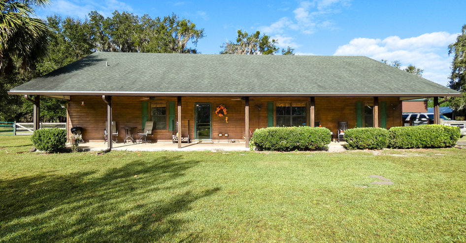 Exterior view of a ranch-style house with green lawn and blue sky.