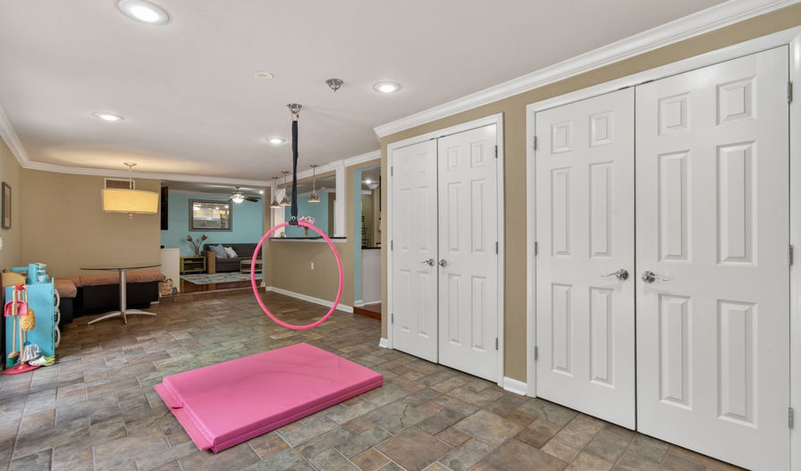Basement with tiled floor, pink mat, and aerial hoop