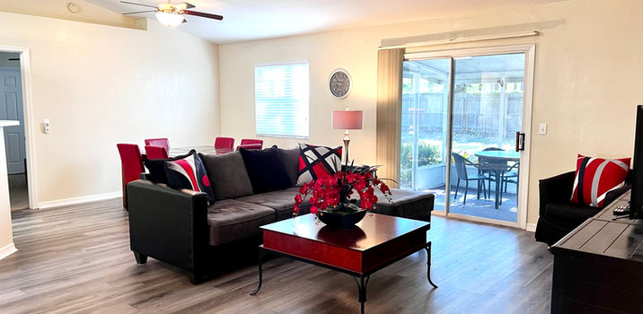 Cozy living room with black sofa and red table, light and bright.