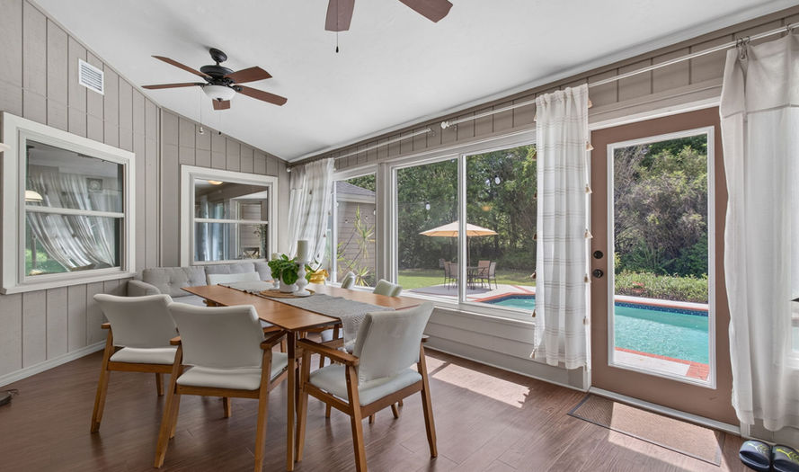 Sunroom with dining set and views of the pool at Royal Gardens
