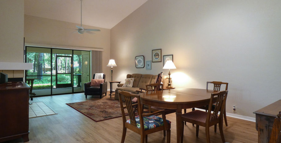 Living room interior with dining table, chairs, and natural light Wood Creek Village