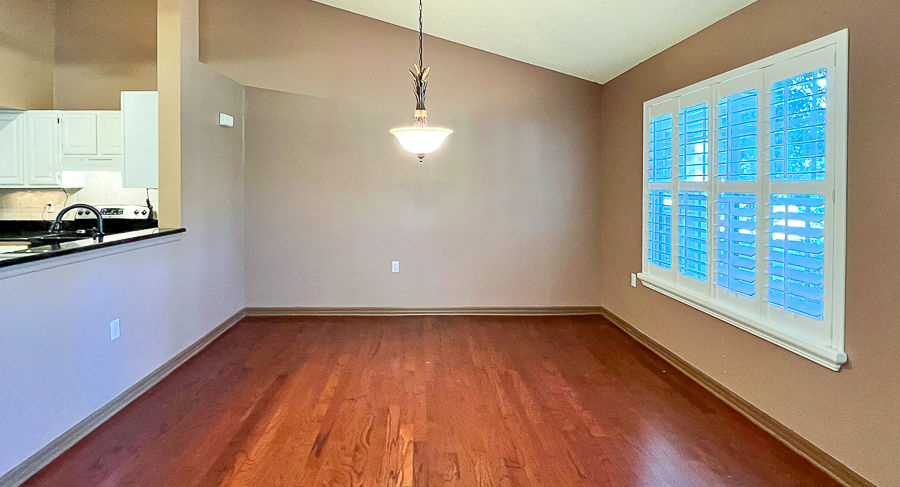 Interior view of a living room with wooden flooring and a window.