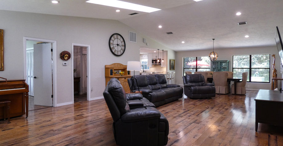 Open living room with a recliner, sofa, and a large clock.