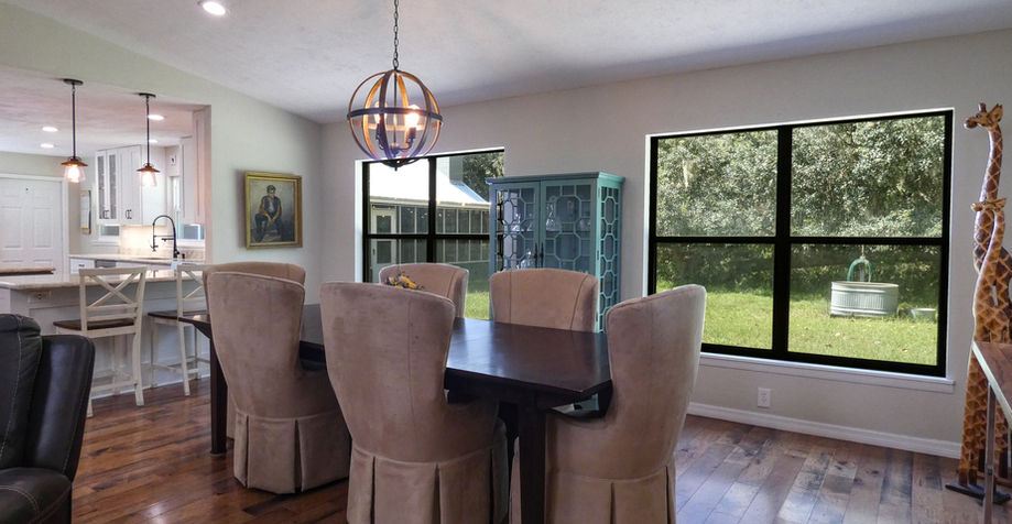 Dining room with table and chairs, visible windows and open kitchen concept.