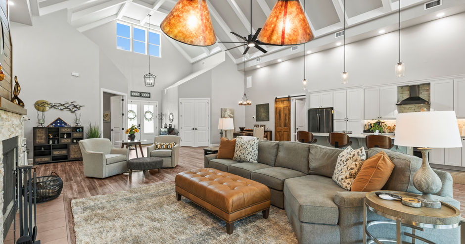 Luxury living room with chandelier lights and leather ottoman, modern design.