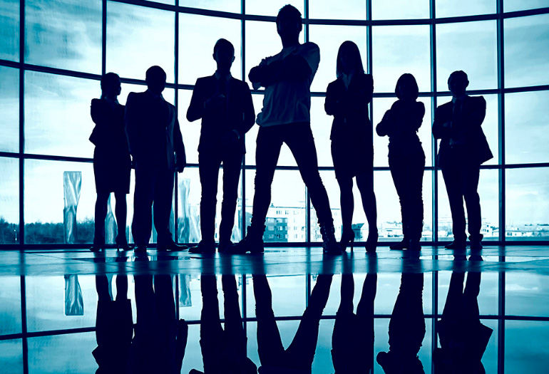 Equipo de profesionales en silueta representando liderazgo organizacional y desarrollo de liderazgo