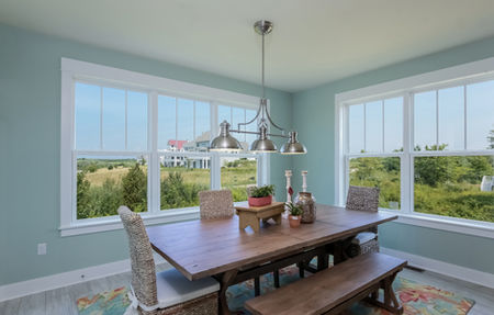 Dining room with a farmhouse table and bench seating in a custom build.