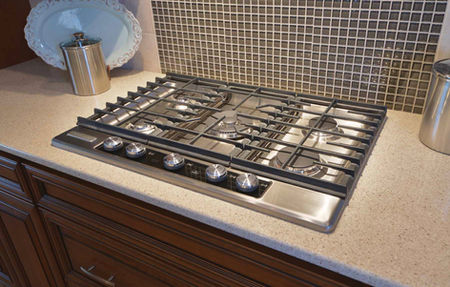 Stainless steel gas stove and tile backsplash detail from the Triple Crown modular home interior photos.