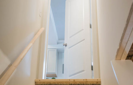 A wood staircase leading down to a basement area.