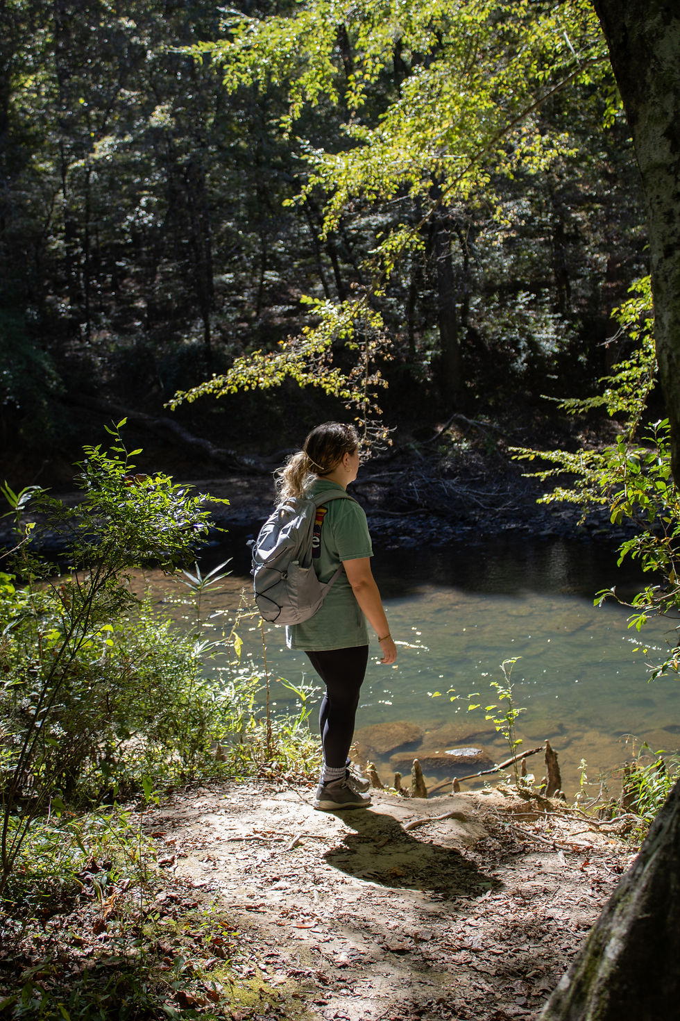 a girl standing at the edge of a river