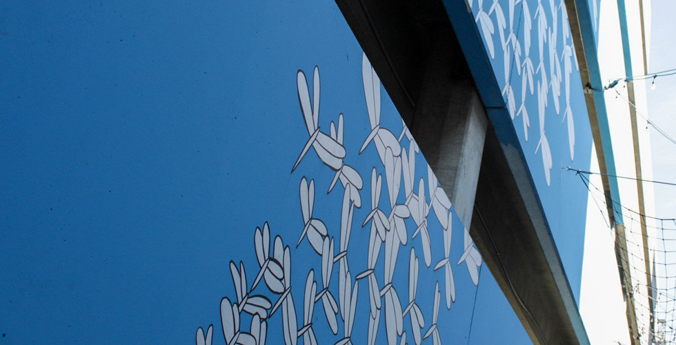 mural of dragonflies on blue background on a parking garage