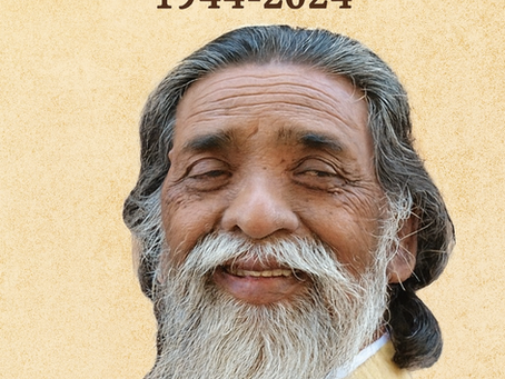 A commemorative image of Shibu Soren, featuring a close-up of him smiling warmly with his signature long white beard and hair. The background is a soft beige, with the text "Remembering Shibu Soren 1944–2024" and the quote "...he gave a voice to the voiceless…" written below.
