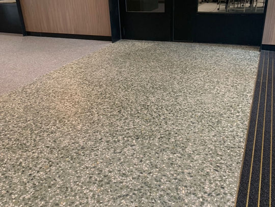 Doorway of Monash University Flats. Polished concrete Pangaea slab. Green highlights Uni