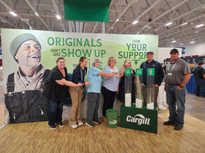 Farmer Angel Network board members and Cargill representatives gather at Cargill’s World Dairy Expo booth, where attendees voted for nonprofit organizations using ping-pong balls.