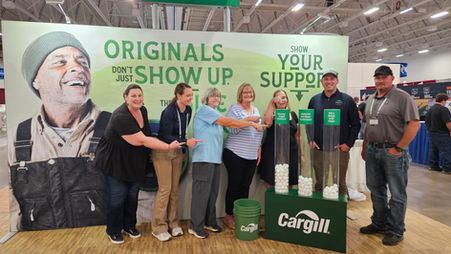 Farmer Angel Network board members and Cargill representatives gather at Cargill’s World Dairy Expo booth, where attendees voted for nonprofit organizations using ping-pong balls.
