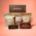 Hamper Co box with three popcorns (Rocky Pop, Heavenly Caramel, Espresso Coffee) in front, and caramel fudge and chocolate
