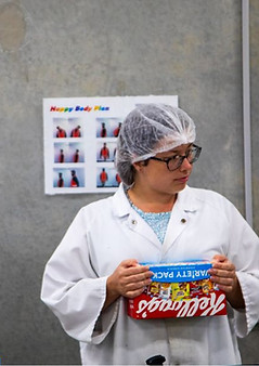 Idf of st george participant sealing a Kellog's variety pack cereal box at Pack Smart as part of work training
