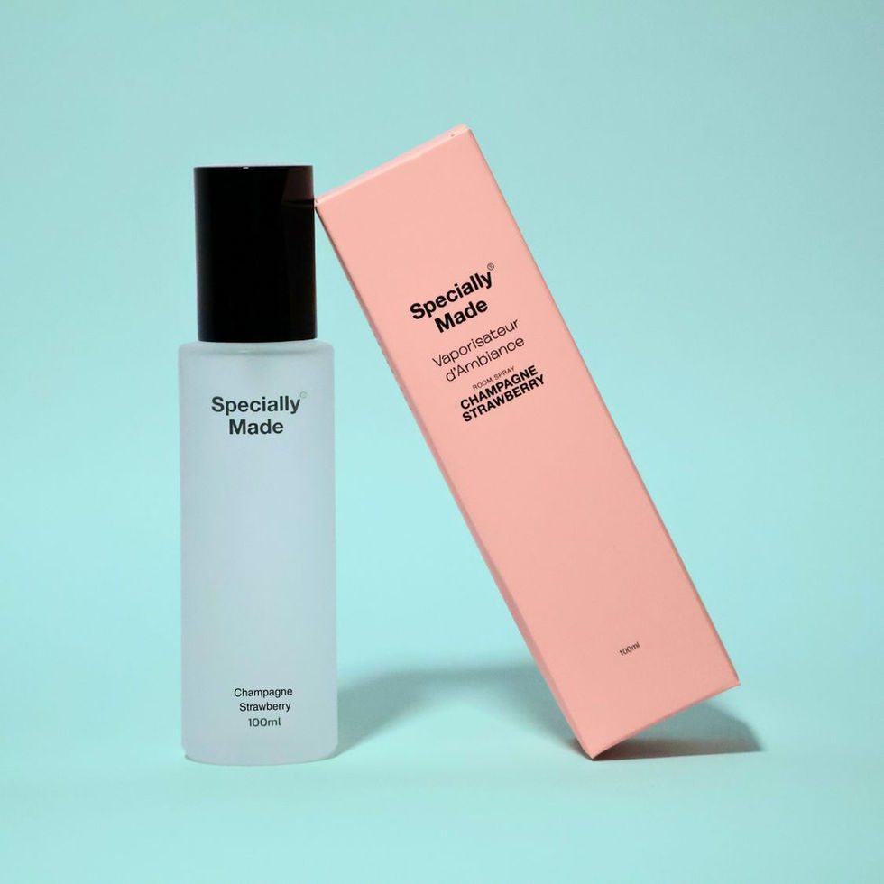 Champagne Strawberry room spray in a frosted glass bottle with its pink box leaning on it. Turquoise background
