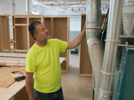 Woodworker inspecting dust collection system