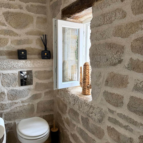 Ce WC, au cœur de la suite La Petite Longère, allie charme authentique et confort moderne.
Les murs en pierre apparente, patinés par le temps, créent une atmosphère chaleureuse et pleine de caractère.