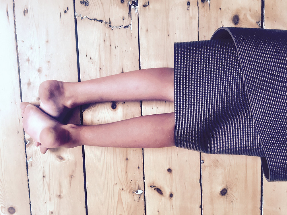 child's feet sticking out of yoga mat
