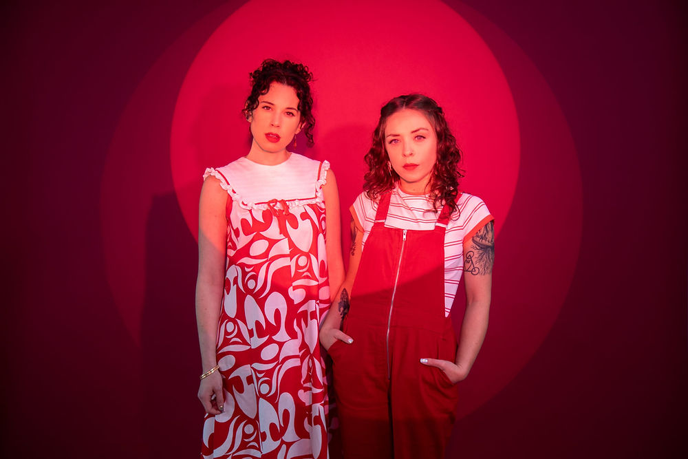 The Pussywillows in red outfits before a red circular spotlight