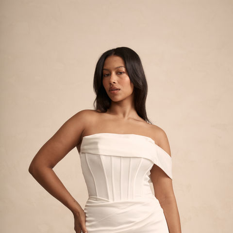 Woman in elegant off-shoulder white satin corset wedding dress.