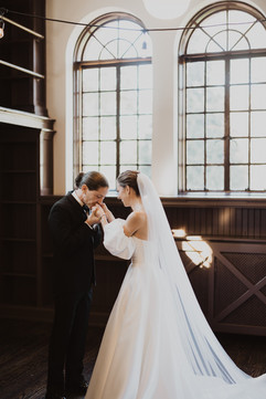 bride and groom during private first look groom kisses brides hand