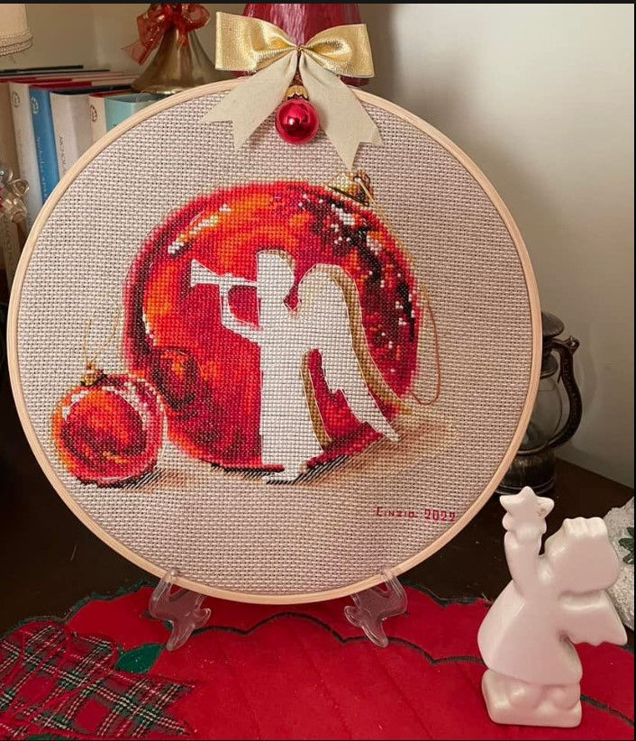 Close-up view of a cross-stitch project displayed in a wooden embroidery hoop