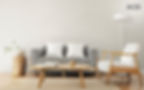 Minimalist living room with neutral tones, featuring a grey sofa, wooden coffee table, and