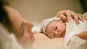 New mom holding her newborn child with skin-to-skin contact.png