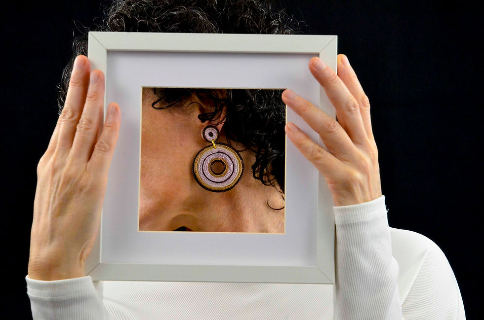Thumbnail: Mujer con pendientes textiles con forma de rueda, hechos con colores combinados.