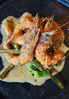 Grilled prawns with a creamy garlic sauce garnished with herbs