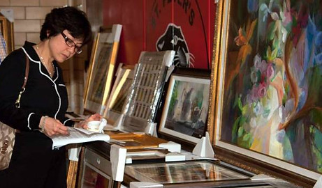 Woman looking at art during preview of a fundraising art auction