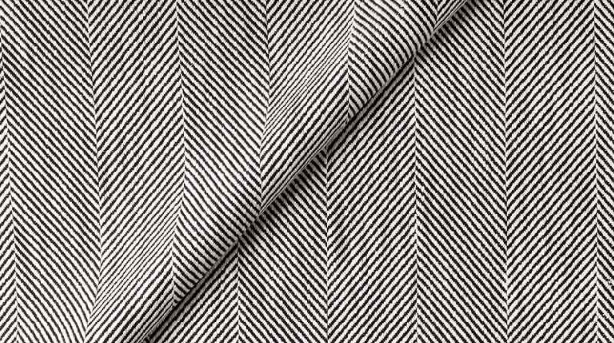 Black and white herringbone patterned fabric, folded diagonally. The zigzag design creates a textured appearance.