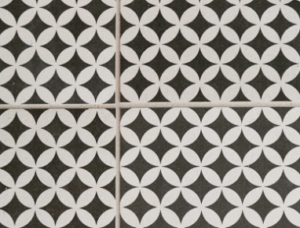 Black and white tiles with circular and petal patterns, creating a geometric design. No text or figures. Sophisticated and orderly mood.