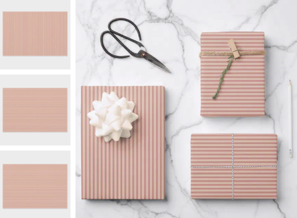 Striped gifts with bows on marble. Scissors, twine, pen nearby. Soft pink tones create an elegant, festive mood.