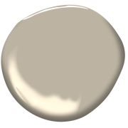 A smooth, round, beige paint splash with a glossy surface and soft shadow on a plain background, reflecting light subtly.