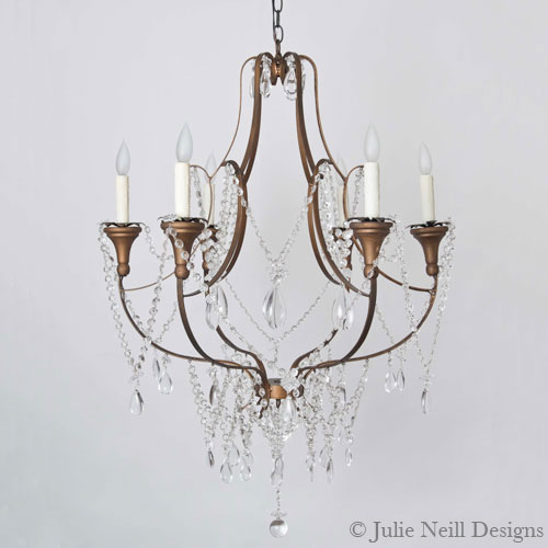 Elegant chandelier with five candle-like lights, bronze frame, and hanging crystals on a white background. Sophisticated mood.