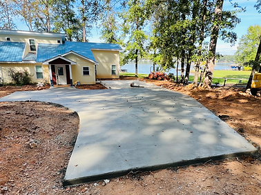Concrete being poured and spread on a driveway, creating a smooth and durable surface.