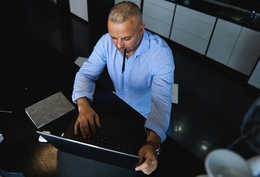 overhead-view-handsome-mature-man-working-remotely-laptop-home-office-concept-distant-remo